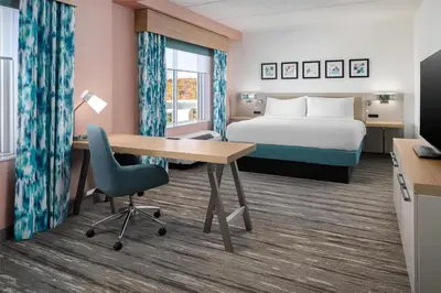 a hotel room with a bed and a desk and chair at Hilton Garden Inn Rockaway in Rockaway