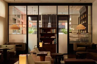 a lobby with tables and chairs and windows at The Mercer in New York
