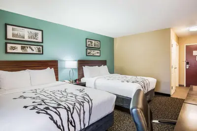 a hotel room with two beds in a room at Sleep Inn & Suites Dunmore in Dunmore