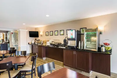 a restaurant with a bar and tables and chairs at Sleep Inn & Suites Dunmore in Dunmore