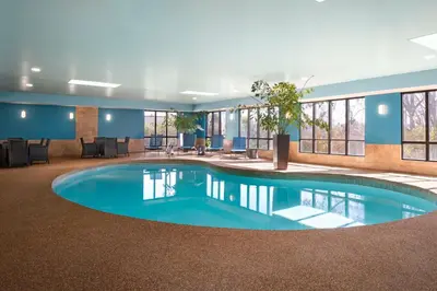 a pool in the middle of a large room with windows at Hampton Inn Chicopee - Springfield in Chicopee