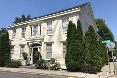 a white house on the corner of a street at Hudson B&B in Hudson