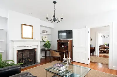 a living room with a fireplace and a table at Hudson B&B in Hudson