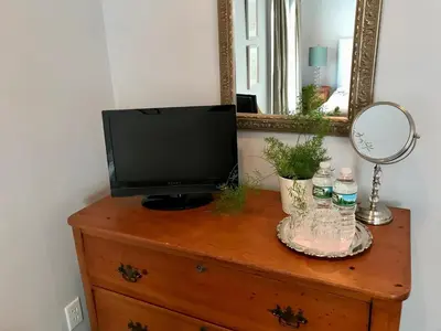 a television on top of a dresser with a mirror at Hudson B&B in Hudson