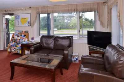 a living room with a leather couch and a tv at Best Stay Inn -Manchester in Manchester