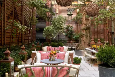 a patio with chairs and a table with flowers on it at Crosby Street Hotel in New York
