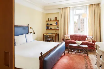 a bedroom with a bed and a couch and a chair at The Greenwich Hotel in New York