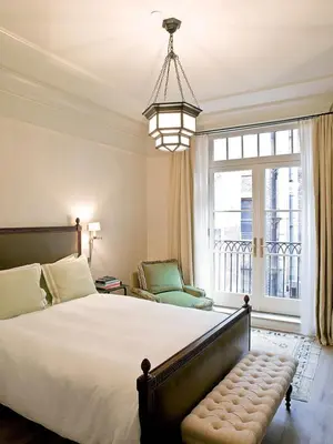 a bedroom with a large bed and a window at The Greenwich Hotel in New York