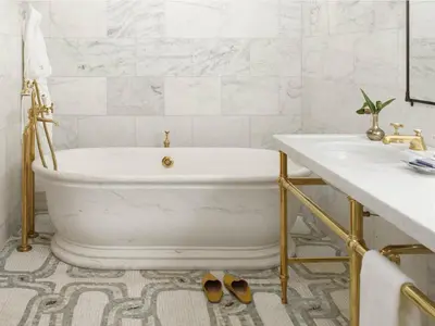 a white bathroom with a tub and a sink at The Greenwich Hotel in New York