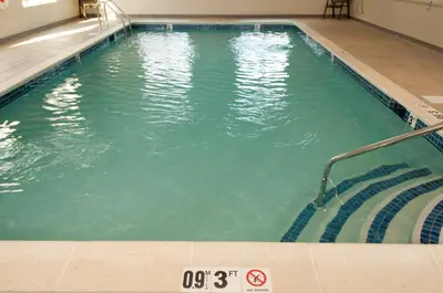 an empty swimming pool with stairs in a building at Holiday Inn Express Vernon-Manchester by IHG in Vernon