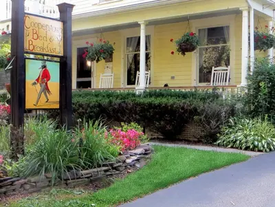 a yellow house with a sign in front of it at Cooperstown Bed and Breakfast in Cooperstown