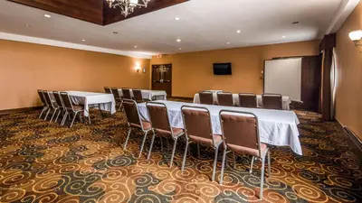 a conference room with tables and chairs and a screen at Best Western Plus The Inn & Suites at the Falls in Poughkeepsie