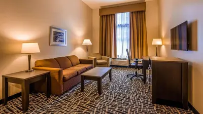 a hotel room with a couch and a table at Best Western Plus The Inn & Suites at the Falls in Poughkeepsie