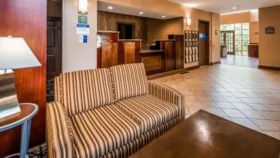 a living room with a couch and a table at Best Western Plus The Inn & Suites at the Falls in Poughkeepsie
