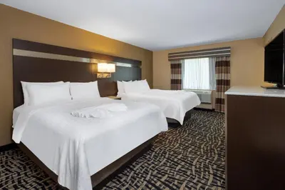 a hotel room with two beds and a television at Holiday Inn Poughkeepsie by IHG in Poughkeepsie