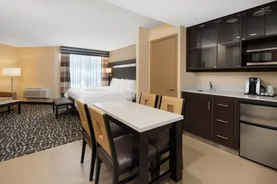 a hotel room with a kitchen and a bedroom at Holiday Inn Poughkeepsie by IHG in Poughkeepsie