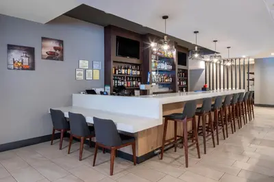 a bar in a restaurant with chairs around it at Holiday Inn Poughkeepsie by IHG in Poughkeepsie