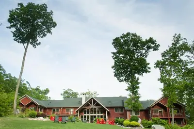 a large red house with trees in front of it at Minnewaska Lodge in Gardiner
