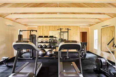 a gym with several treadmills and exercise machines at Troutbeck in Amenia