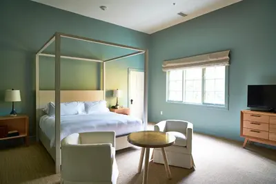 a bedroom with a large bed and a table and chairs at Troutbeck in Amenia