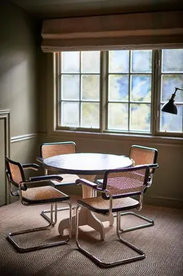a table and chairs in a room with a window at Troutbeck in Amenia