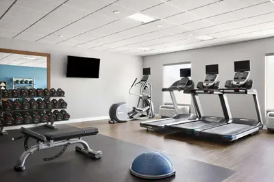 a gym with several treadmills and machines in a room at Hampton Inn & Suites West Haven in West Haven