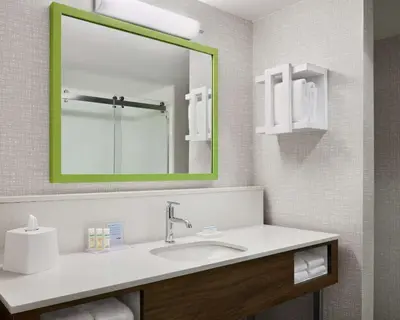 a bathroom with a sink and a large mirror at Hampton Inn & Suites West Haven in West Haven