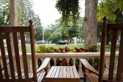 two chairs and a wooden table on a porch at The Inn at Cooperstown in Cooperstown