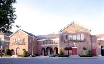 a brick building with two flags in front of it at The Inn at Cooperstown in Cooperstown