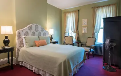 a bedroom with a large bed with a white bedspread at The Inn at Cooperstown in Cooperstown