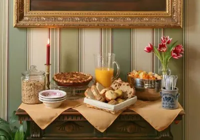 a table with food and drinks and a candle on it at The Inn at Cooperstown in Cooperstown