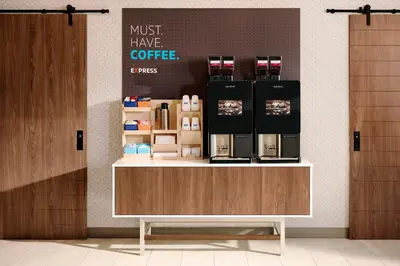 a coffee shop with a counter with a coffee maker on it at Holiday Inn Express & Suites Jersey City North - Hoboken by IHG in Jersey City