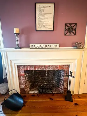 a fireplace with a sign on top of it at The Black Walnut Inn in Amherst