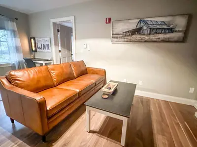 a brown leather couch in a living room with a table at The Black Walnut Inn in Amherst