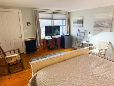 a bedroom with a bed and a flat screen tv at The Black Walnut Inn in Amherst