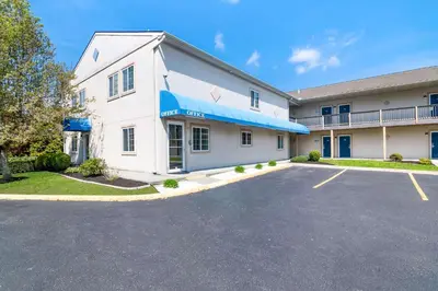a large white building with a parking lot at Econo Lodge Bethel - Danbury in Bethel