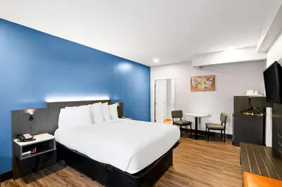 a hotel room with a bed and a blue wall at Econo Lodge Bethel - Danbury in Bethel