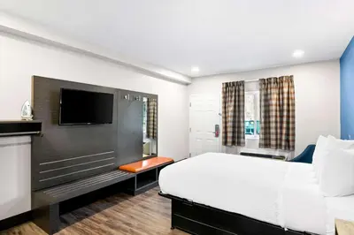 a hotel room with a bed and a flat screen tv at Econo Lodge Bethel - Danbury in Bethel