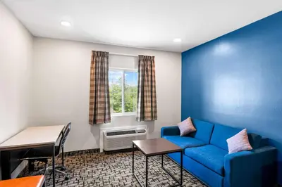 a living room with a blue couch and a window at Econo Lodge Bethel - Danbury in Bethel