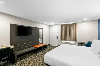 a hotel room with a bed and a flat screen tv at Econo Lodge Bethel - Danbury in Bethel