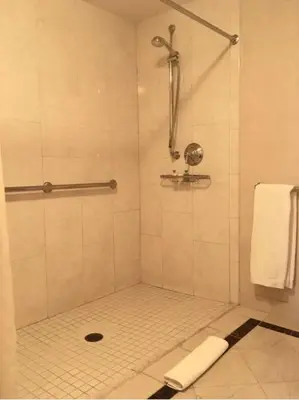 a bathroom with a shower with a tile floor at Delamar Greenwich Harbor in Greenwich