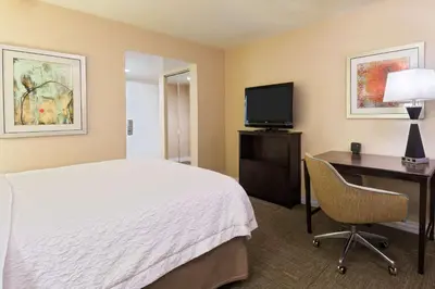 a hotel room with a bed and a desk and a television at Hampton Inn White Plains/Tarrytown in Elmsford