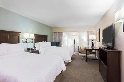 a hotel room with two beds and a flat screen tv at Hampton Inn White Plains/Tarrytown in Elmsford