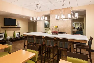 a large dining room with a bar and chairs at Hampton Inn White Plains/Tarrytown in Elmsford