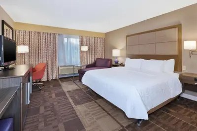 a hotel room with a bed and a flat screen tv at Hampton Inn Waterbury in Waterbury