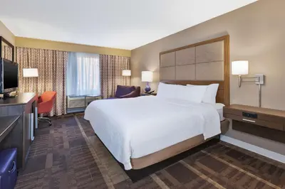 a hotel room with a bed and a flat screen tv at Hampton Inn Waterbury in Waterbury