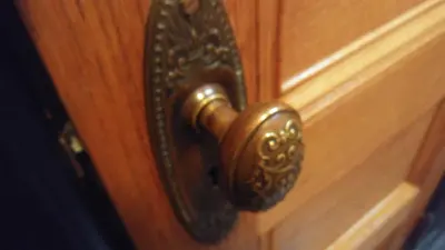 a bronze door knob on a wooden door at The Harlem Flophouse in New York