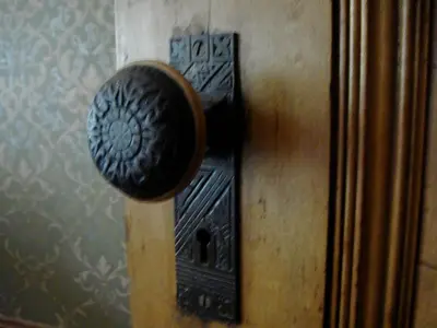 a bronze door knob on a wall at The Harlem Flophouse in New York