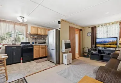 a kitchen with a stainless steel refrigerator and a tv at Pocono cabin with hot tub and private pool at Shawnee Mtn in East Stroudsburg