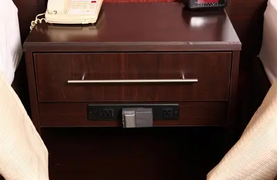 a wooden nightstand with a phone on top of it at Red Roof Inn PLUS+ West Springfield in Springfield